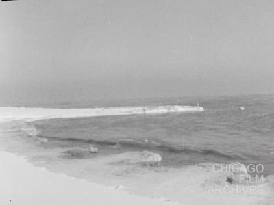 Chicago---Lake scenes of snow &amp; waves, skyline, Christmas shoppers, policemen directing traffic, etc. Sil. uncut neg. 12-21-60