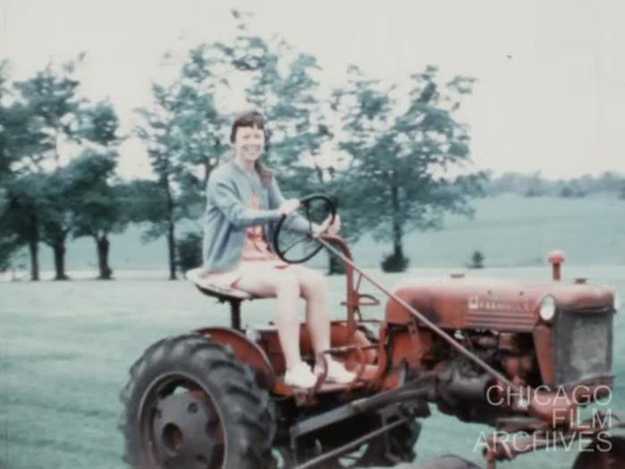 [1969, July: Chas. + Ann at Walbridge Home Outside on Tractor]