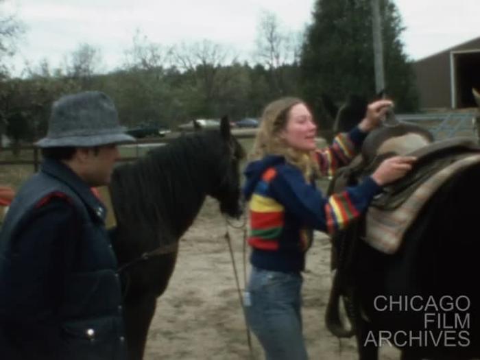 Bob Malak tries to get on a horse but falls. Then he gets on the second time he tries. Ann said that she has been riding since she was 5 years old. October 16, 1982